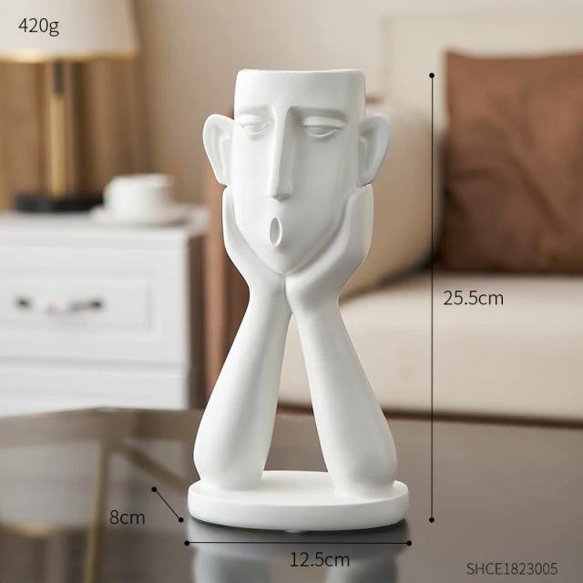 تمثال ثلاثي لوجوه عاطفية في أصيص الزرع