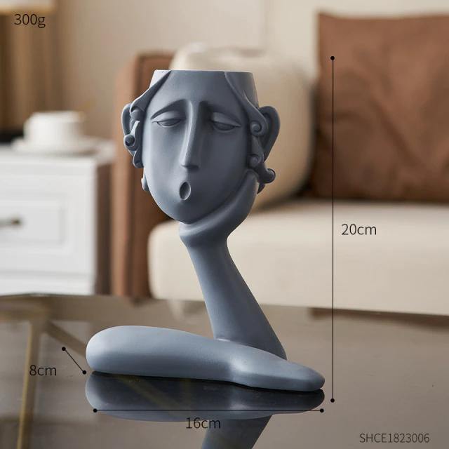 تمثال ثلاثي لوجوه عاطفية في أصيص الزرع